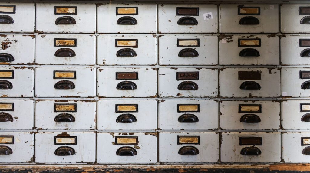 Rows of labeled index card drawers in a filing cabinet, representing manual skill tagging of candidate records