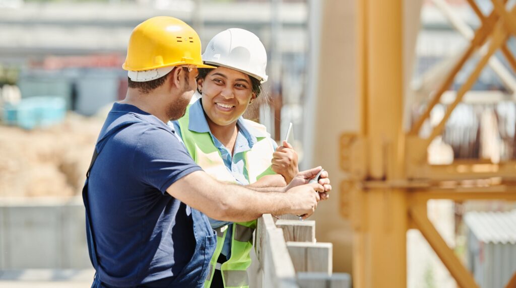 A site-based worker checking a text message on a mobile phone during a break