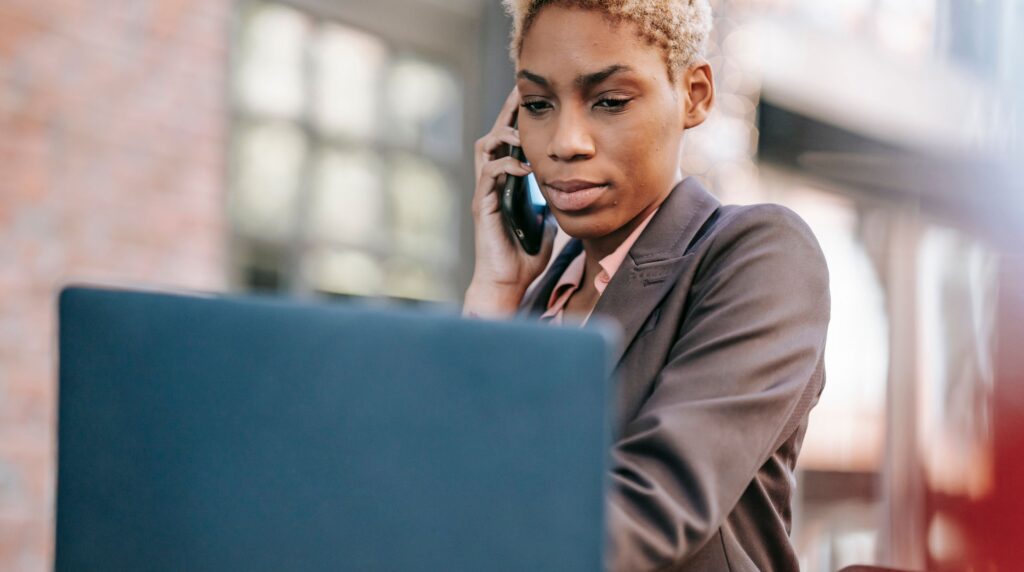 Recruitment consultant on a business development call at a desk in an agency office